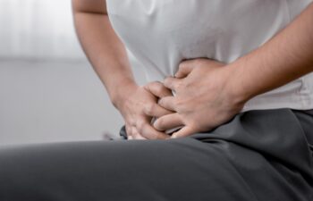 young woman hands in belly, stomach pain from food poisoning, abdominal pain and digestive problem, gastritis or diarrhoea. Abdomen inflammation, menstrual period people.